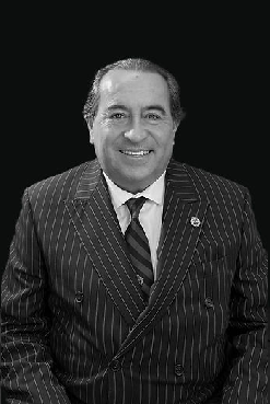 A man in a suit and tie smiling for the camera.